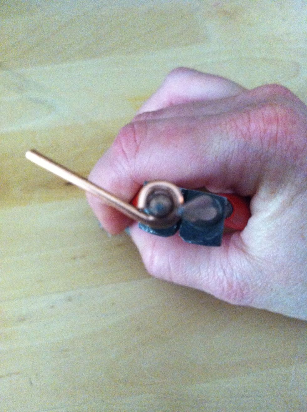 Pick up the remaining 1 1/4" piece of wire and use the round nose pliers to make a loop at one end.