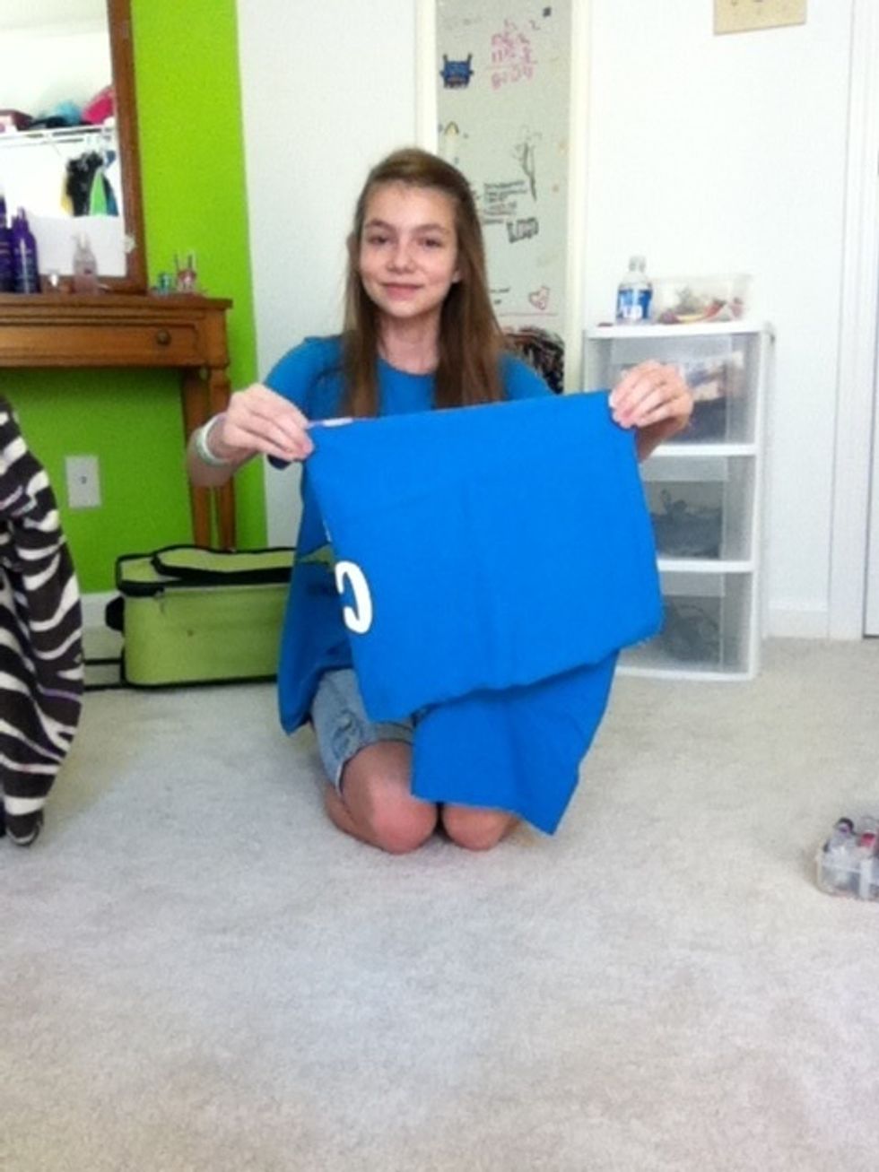 Pick up the shirt and shake it out.