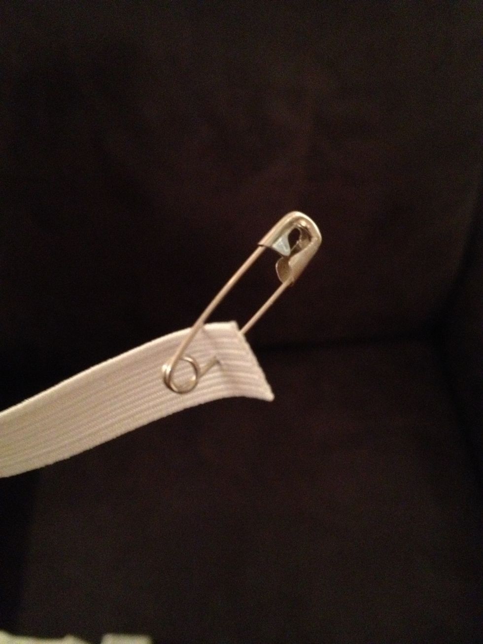 Pin a safety pin to one end of the elastic.