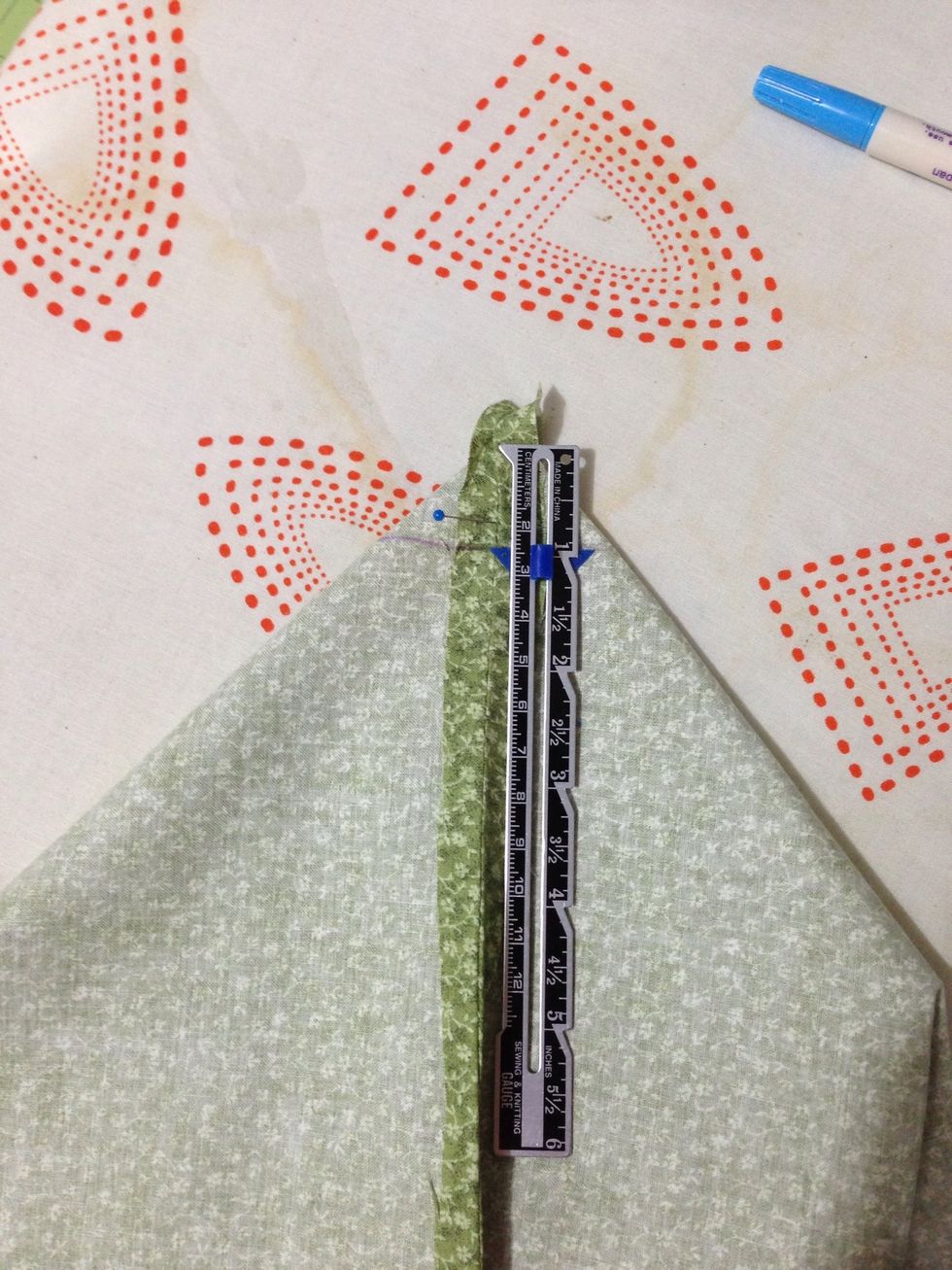 Pin bottom seam of bag to one side seam creating a triangle. To make sure it's even put a pin through the top seam & if it comes out the seam on the other side you are good. Measure 1/2 in & mark it.