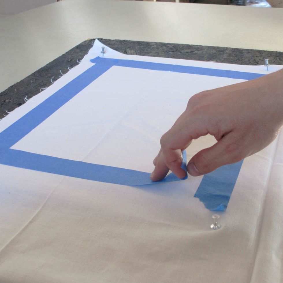 Pin your fabric on a flat surface. For straight lines, use painters tape and press firmly so that the Inkodye doesn't bleed under the tape. You can try it freehand as well.