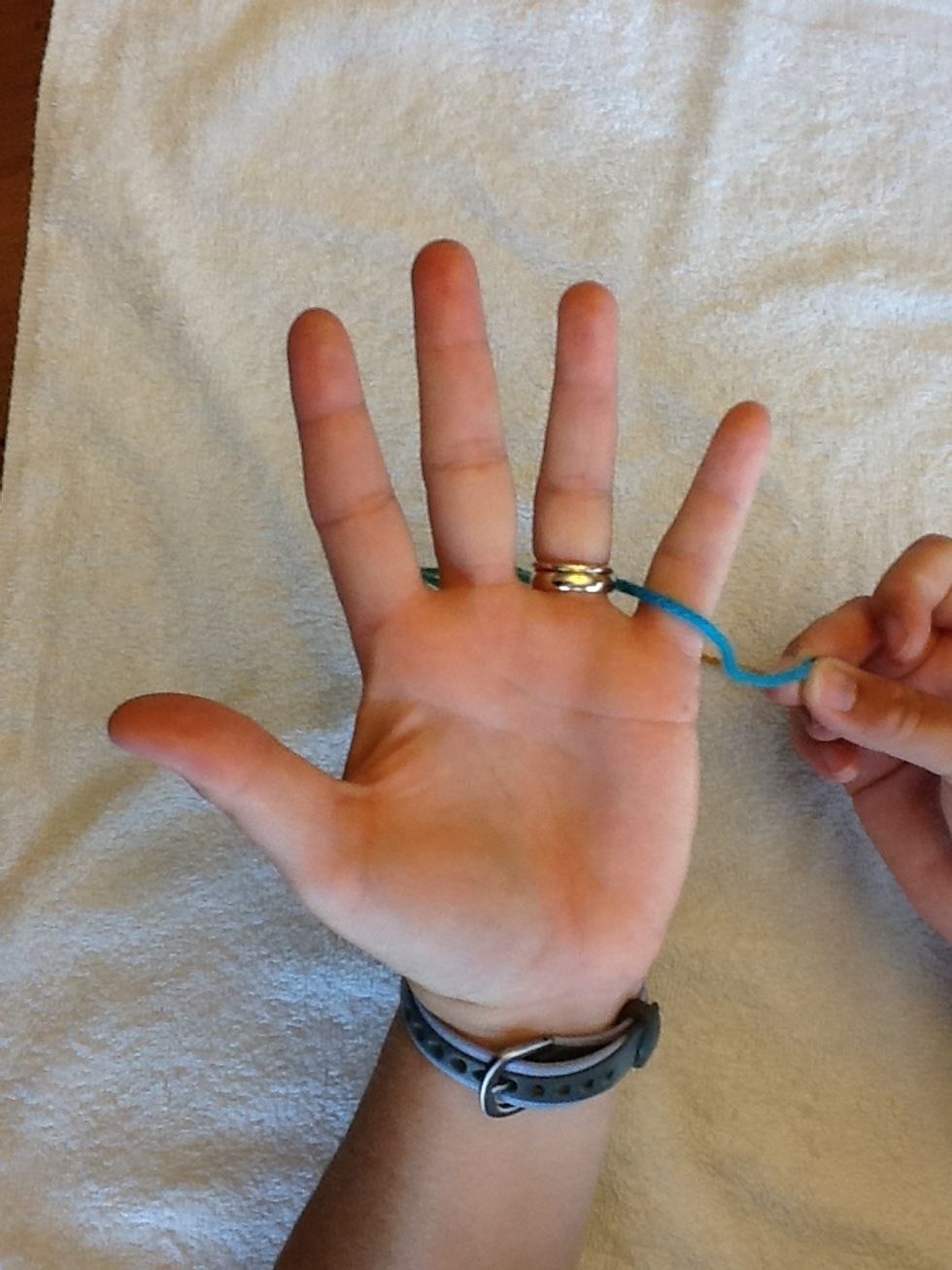 Pinch end of yarn and slip through ring finger and pinky. Leave 3" of yarn hanging off the right side of the pinky. I call this " the tail".