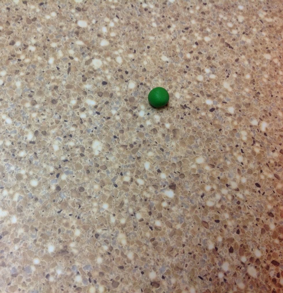 Pinch off another, smaller piece of green clay. Form a ball and place it on the hard surface.