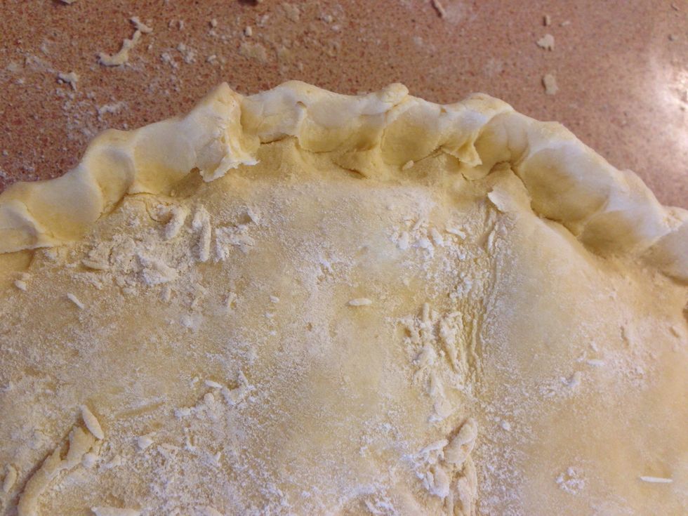 Pinch the edges together to give it a good pie crust. You will most likely need to trim excess dough off. Also use water when needed to help form the crust edge.