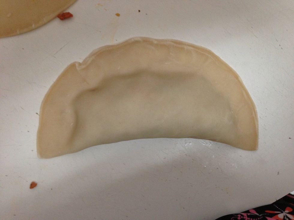 Pinch the ends together tightly to prevent the empanada from opening during the cooking process.