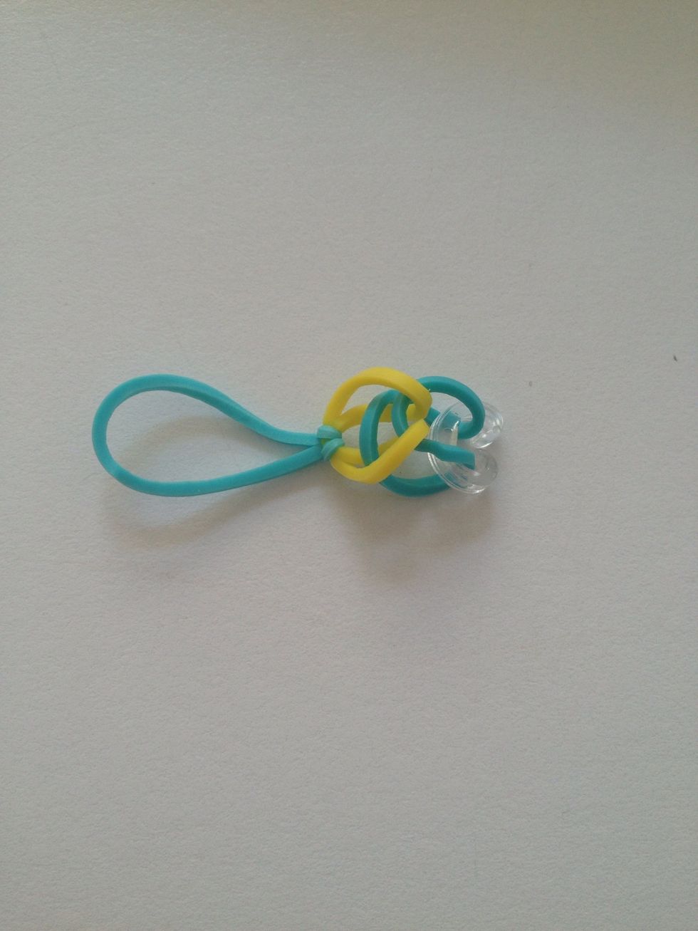 Pinch the next color rubber band and loop it through the first rubber band. Continue doing this alternating colors until the bracelet is the size of your wrist.