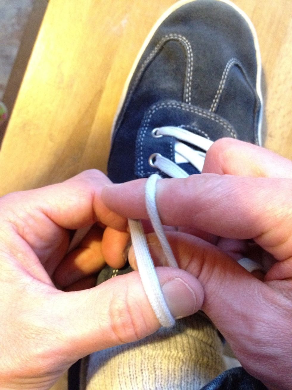 Pinch the opposite lace between thumb and finger.