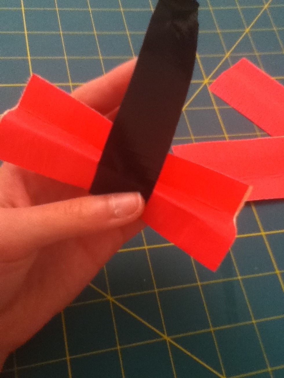 Pinch the pink tape in the middle and use one black piece to wrap around it so it will stay together.