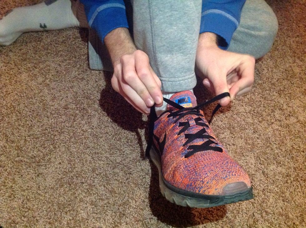 Pinch the shoe laces in between your fingers approximately two inches from the surface of your foot.