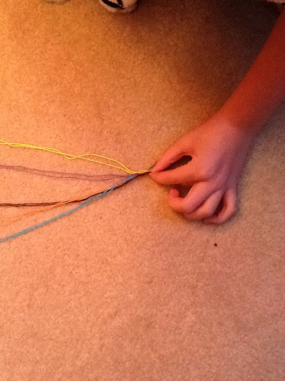 Pinch the top of the strings and tie a knot.