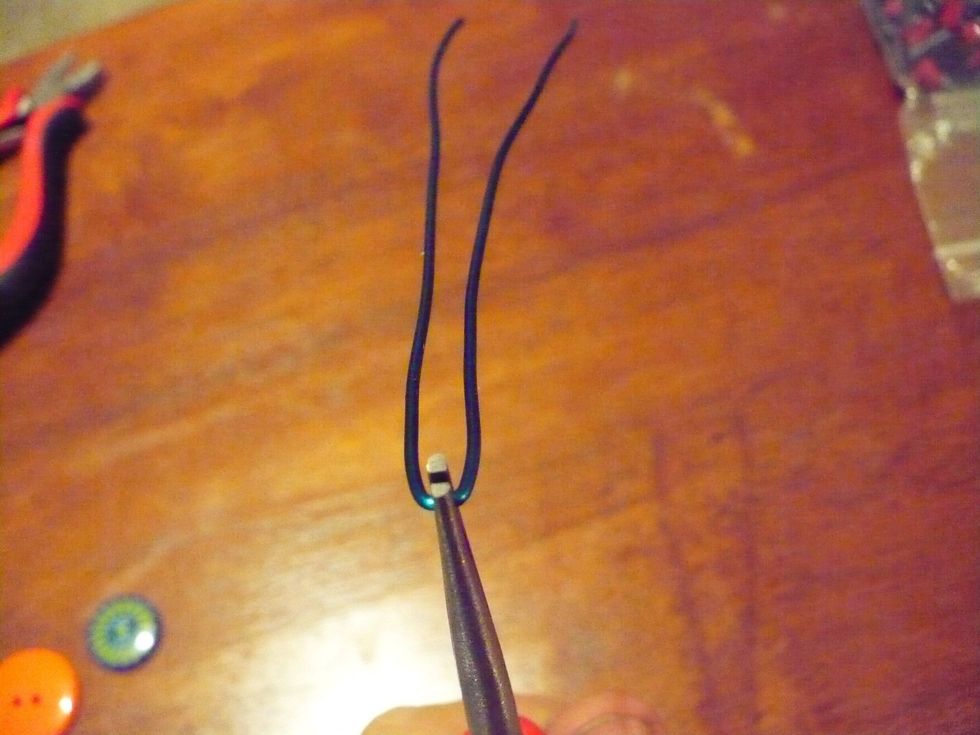 Pinch the wire as close to the center as possible with the chain nose pliers. Pull the two sides of the wire at a straight angle with the pliers like so.