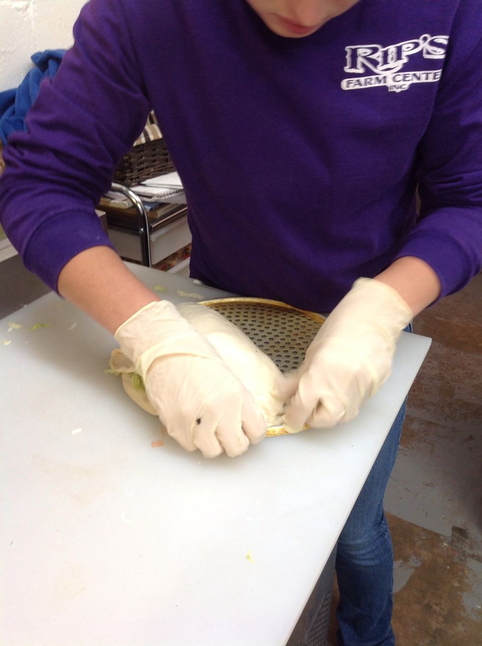 Pinching the ends of the calzone to seal all the toppings inside