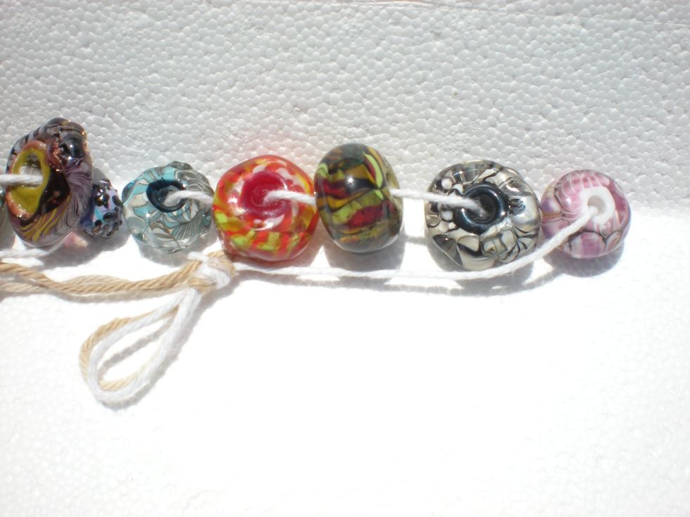 Pink & Green beads are smoothed round beads with flat bead holes. Compare bead holes with deep 'innies' of black/white & red beads. Deep innies make stronger bead & don't fray jewelry cord/findings.