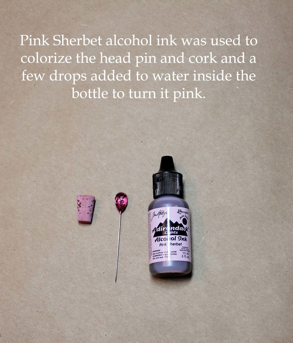 Pink Sherbet alcohol ink was used to color the headpin and the cork of the bottle. Cut the shaft of the pin short and stick it into the cork. Add a few drops of ink to water in the bottle to color.