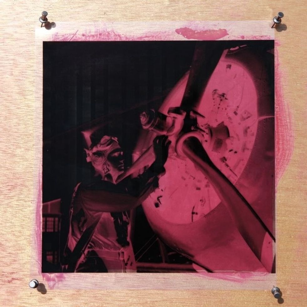 Pinning your negative down during exposure will keep it from blowing away if there's wind, but the negative can separate from the coated material, resulting in poor contact and a blurry image.