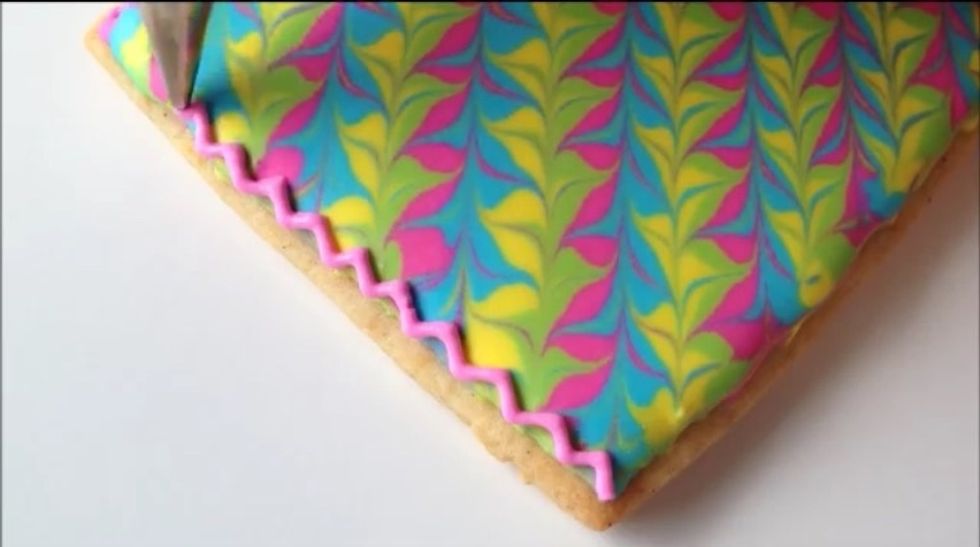Pipe a zig zag pattern on the edge of the frosting to make a border.