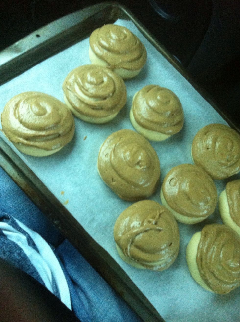 Pipe all the the buns. Make sure to use a good amount because it is going to cover the entire bun but not as much as this sorry or they will join. Don't worry if it looks bad. (And yes, I am in a car)