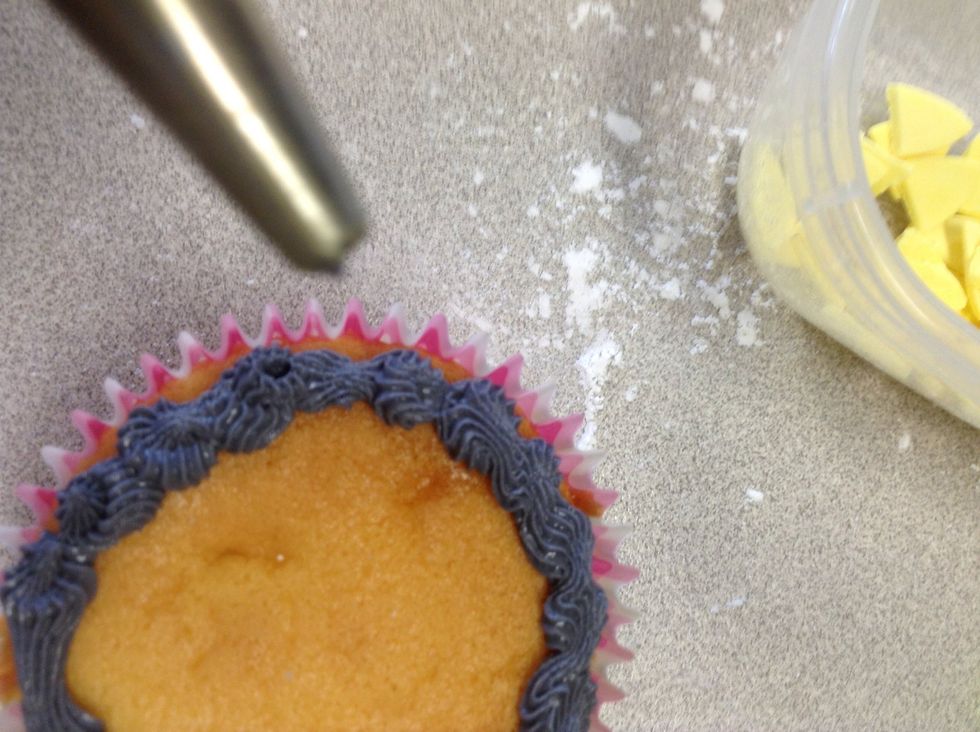 Pipe around the edge of the cupcake with a star novel