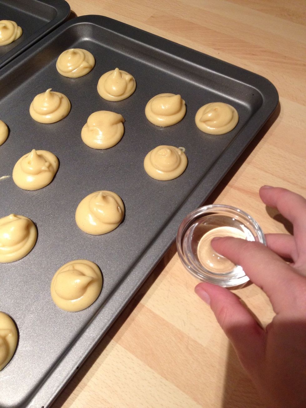 Pipe the dough out on two baking trays, about 30 blobs. Tap your finger into water and smooth the tops, it will make them crispier and smoother.