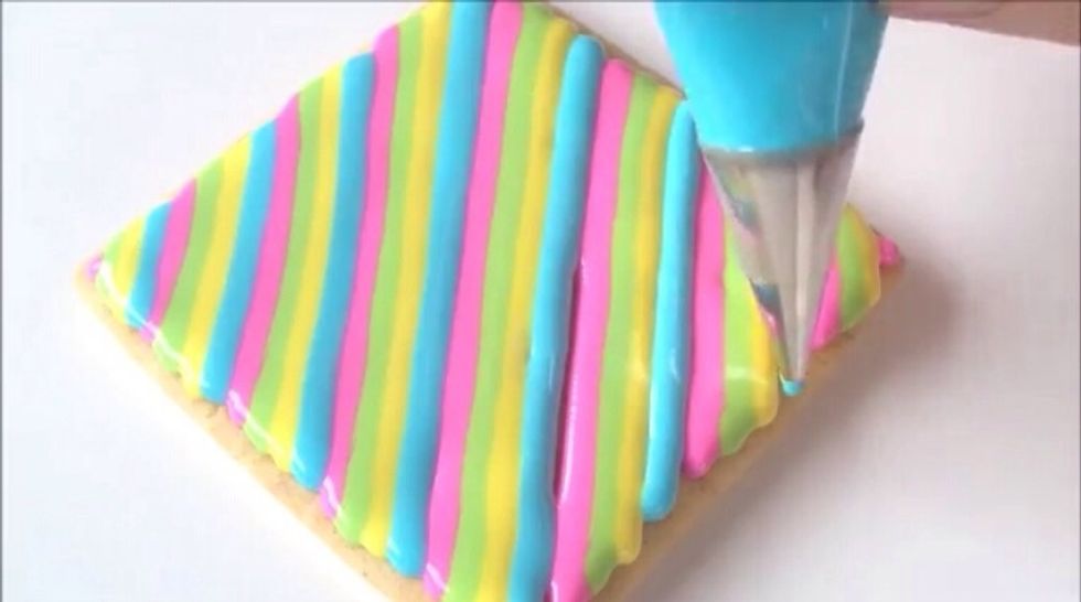 Pipe the forth set of stripes onto the cookie next to the third and first set of stripes.