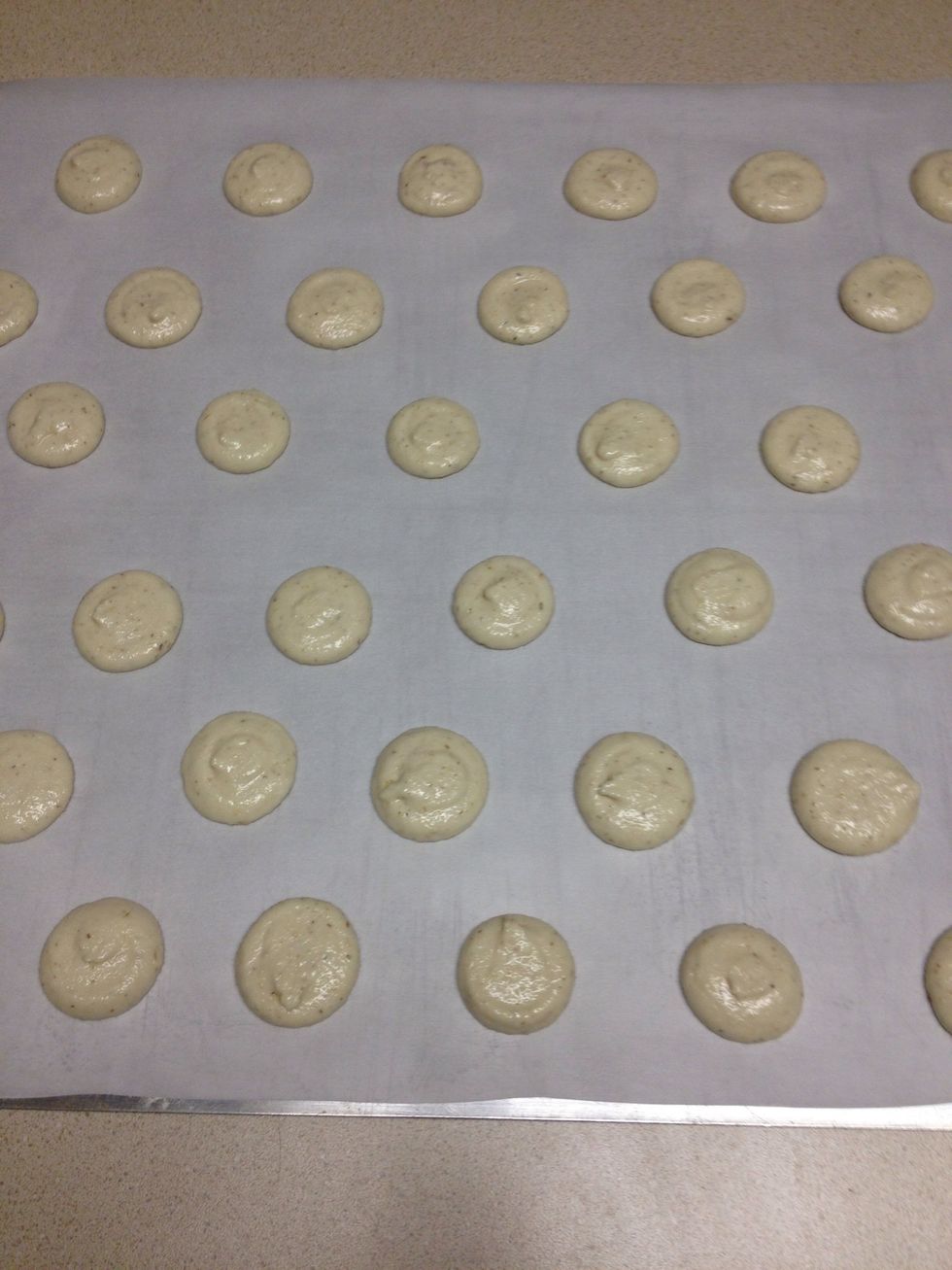 Pipe the macarons onto the parchment paper in the size you want.  Tap the baking sheet firmly on a counter to flatten the cookie.
