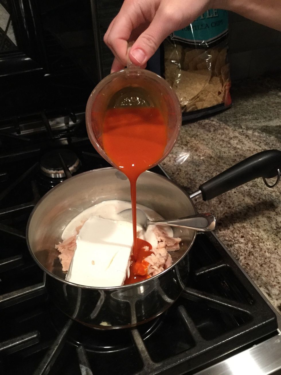 Place 1-10oz can of chicken, 1-8oz. cream cheese, 1/2 cup of ranch and 1/2 cup of hot sauce in saucepan. Tip: Place chicken in first, then slice it into smaller pieces to make dip less chunky.
