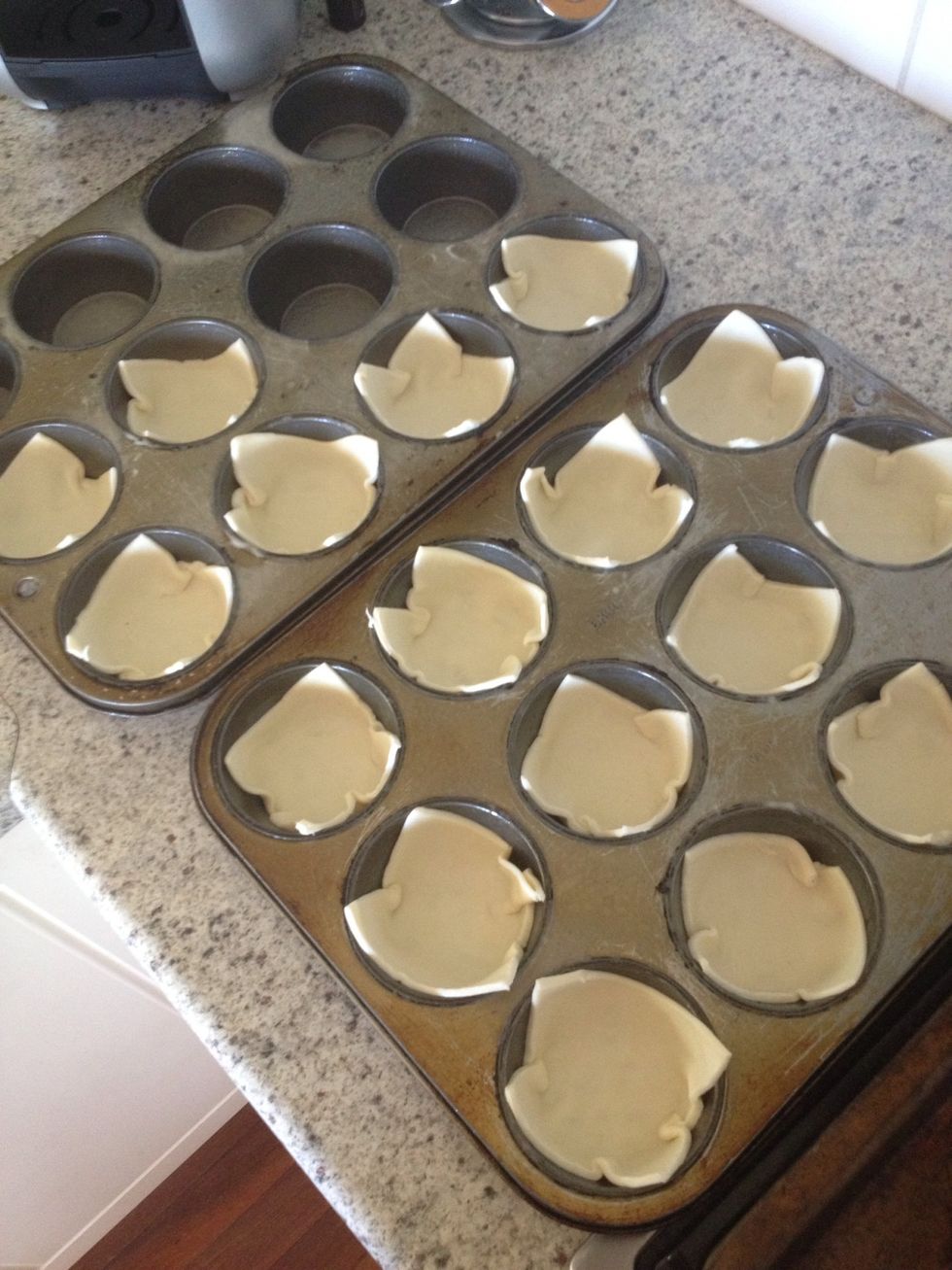 Place 1 pastry square into each hole in the muffin tin. Make sure to push it right to the edges so there's no air bubbles. It should look like this.