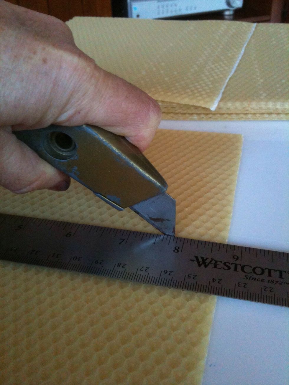 Place 1 sheet of wax horizontally in front of you.  Measure the right side and cut a small slit at the halfway mark.  Do the same on the left side. Measure and cut the sheet horizontally in half.