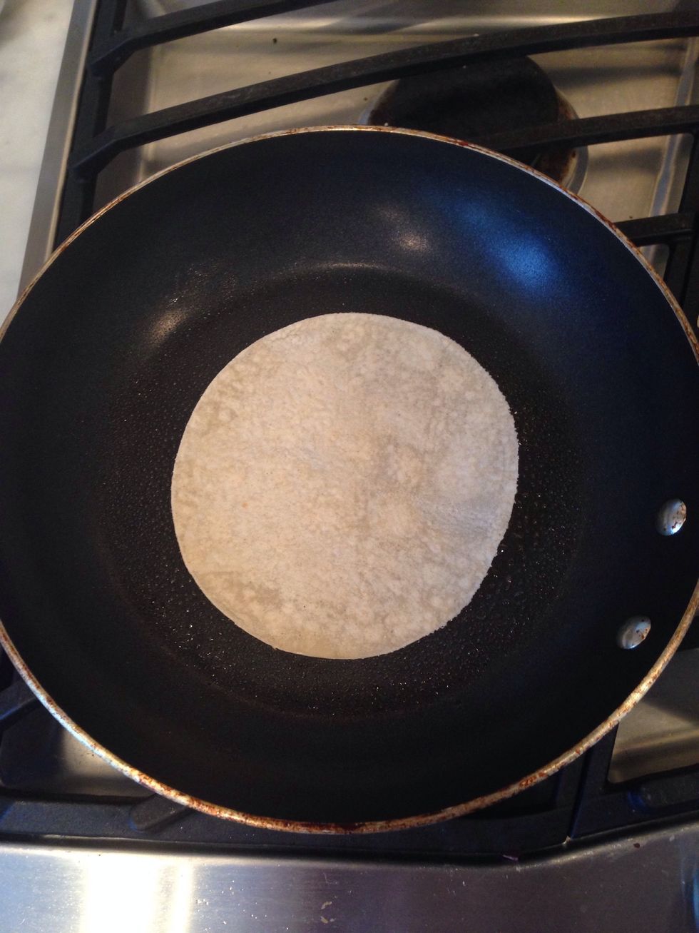 Place 1 tortilla in the pan