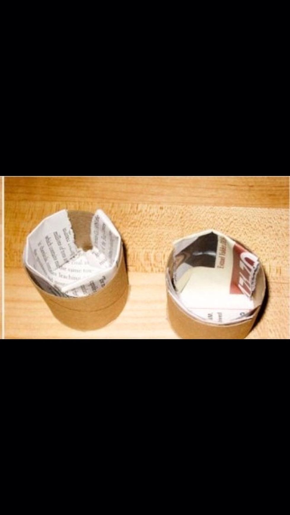 Place 2 newspaper strips (folded in half) on the bottom of the roll by having the 2 ends stick up. On the 2 ends, put a little glue to secure. Roll up other strips and place into roll.