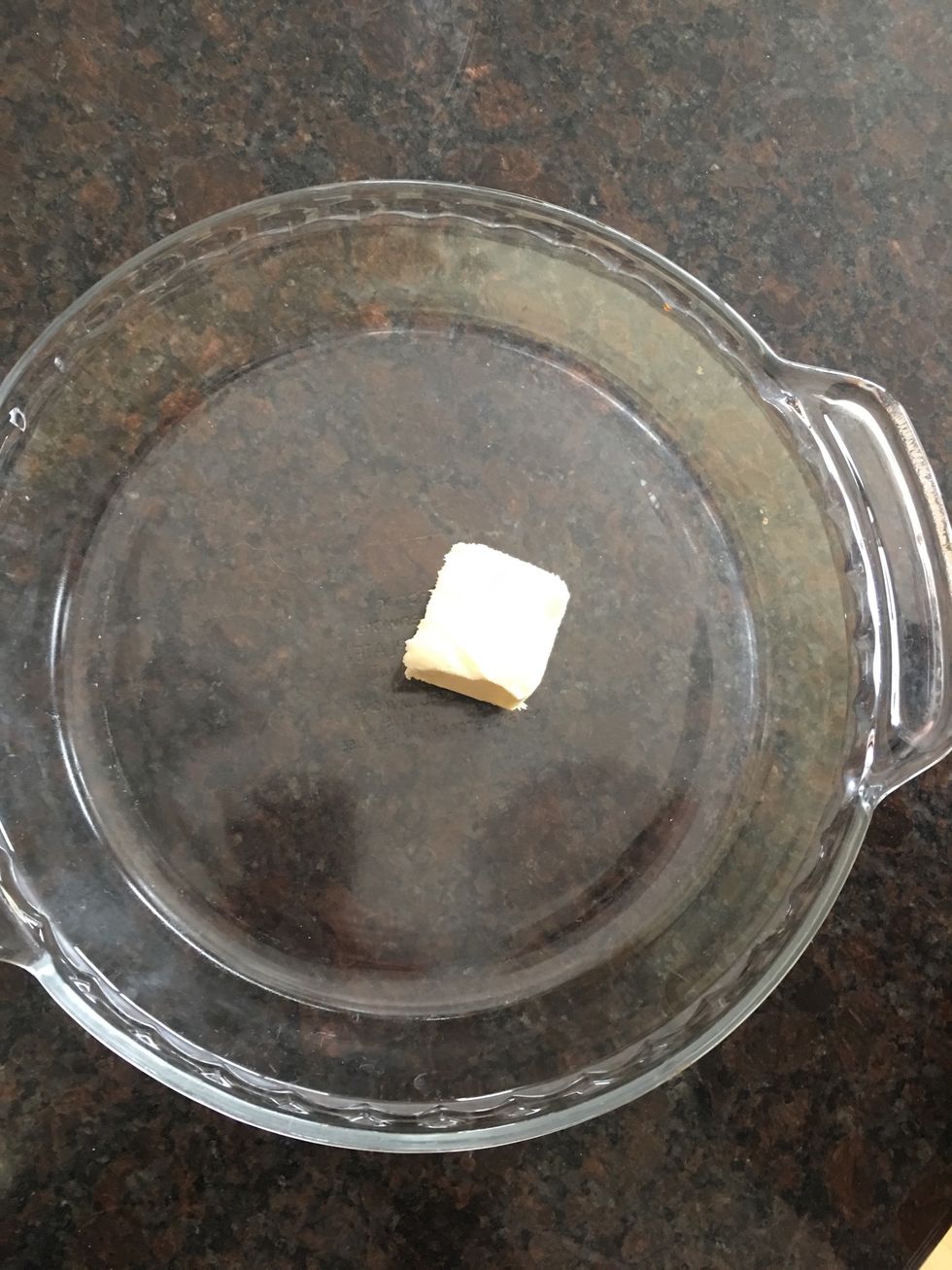 Place 2 Tablespoons butter or margarine in 9 x 1 1/4 inch pie plate.