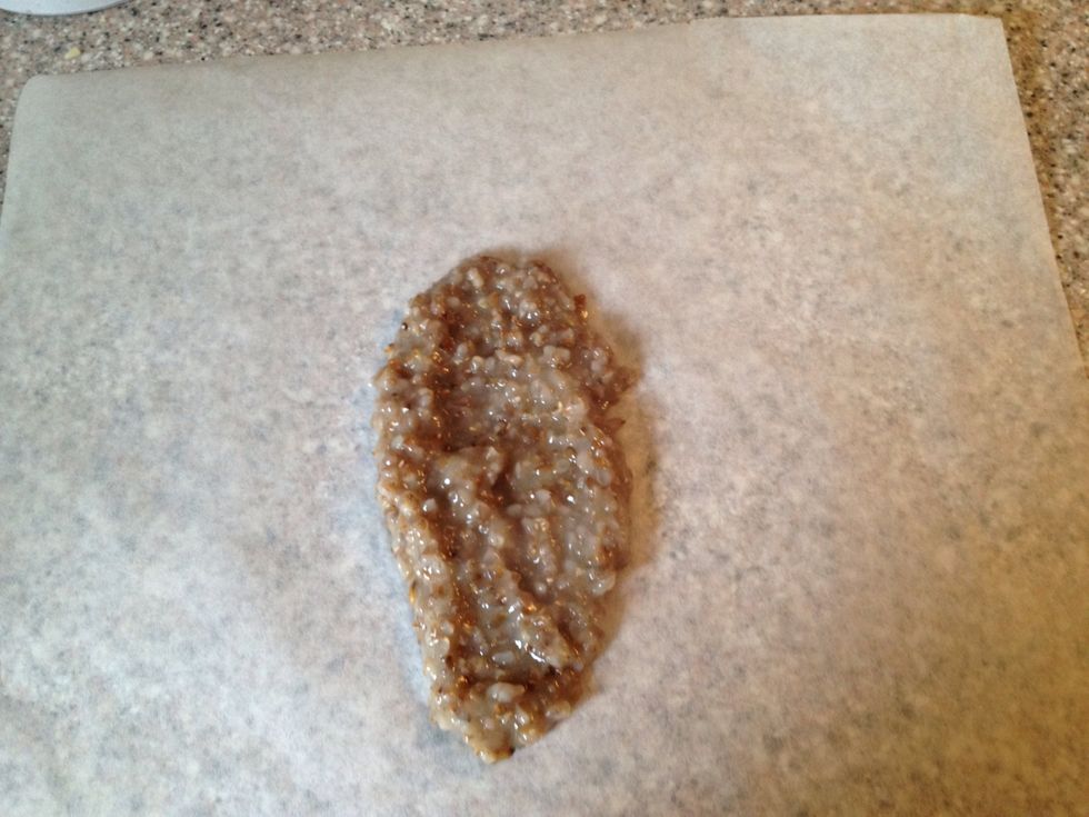 Place 2 tablespoons of boiled rye on the middle of your baking paper. Smear it out a bit.
