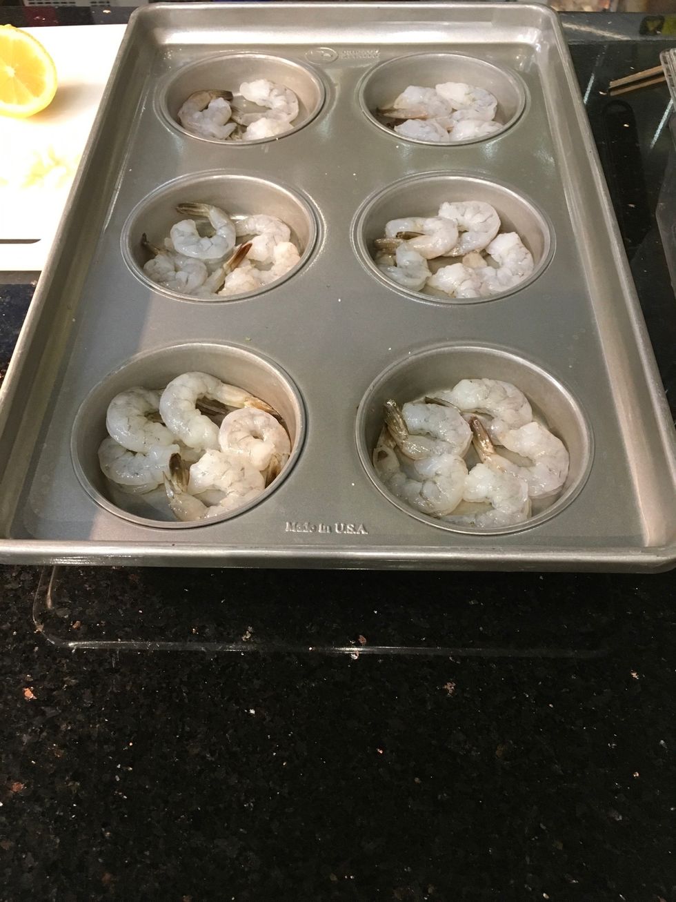 Place 4-5 raw shrimp in each section of the pan.
