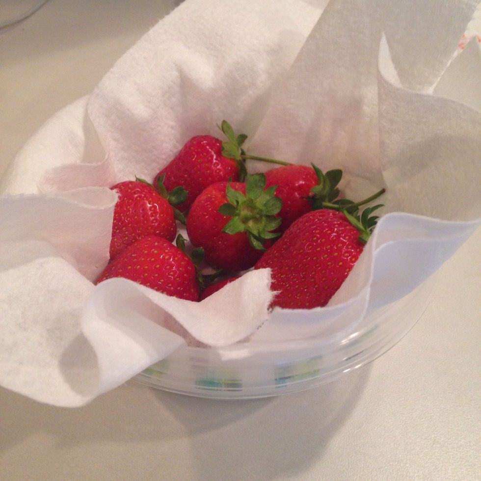 Place a clean paper towel in an air-tight container and add strawberries.