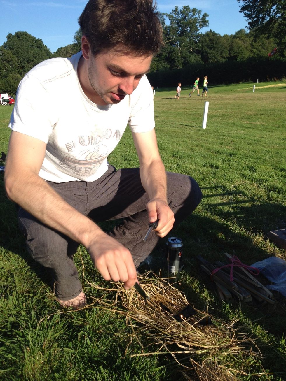 Place a couple of pieces of char cloth on the grass and strike firmly the Firestone to cause sparks to land on cloth. (no char cloth or firestone? Use matches!)