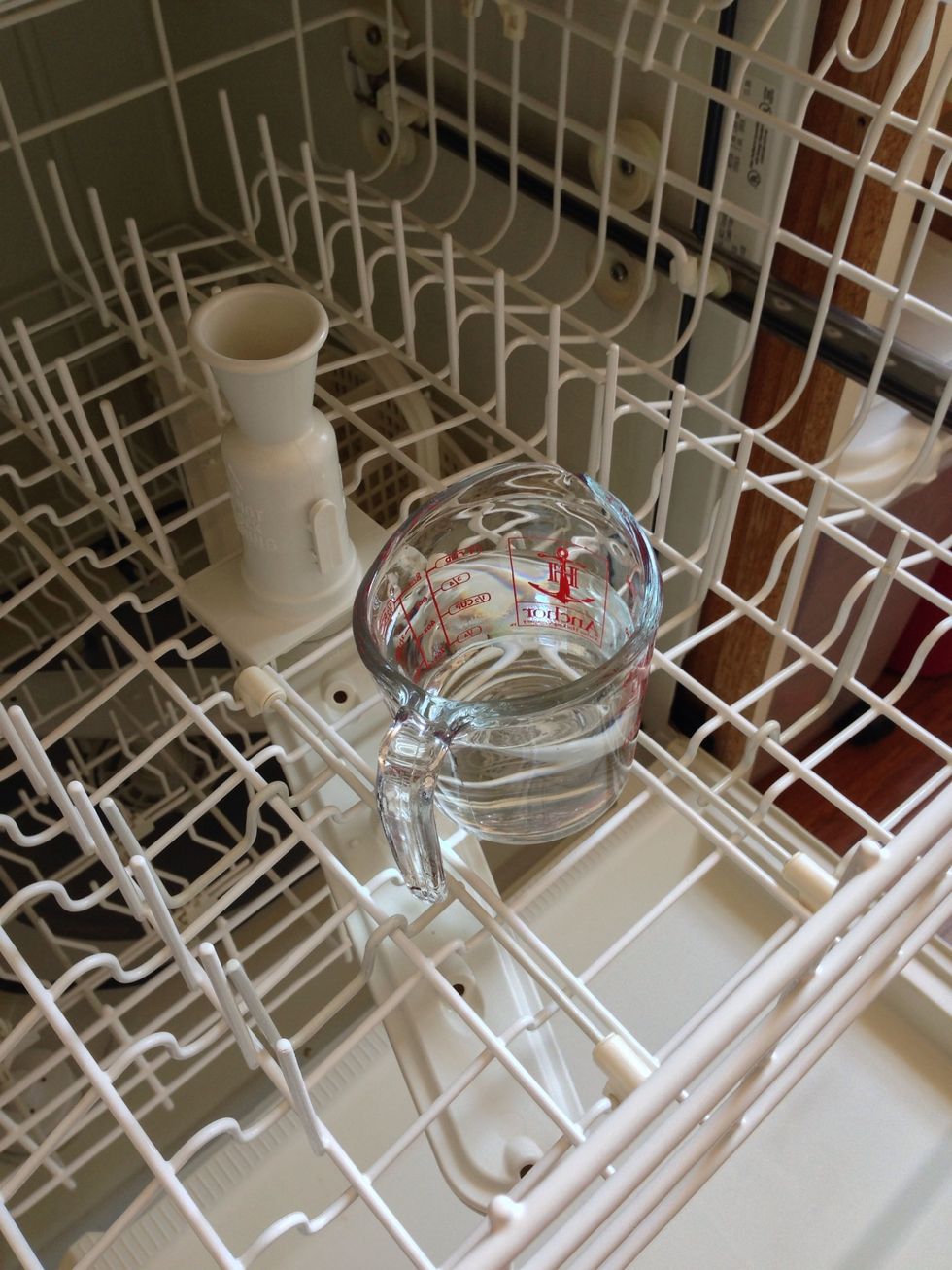 Place a cup of vinegar in the top rack.