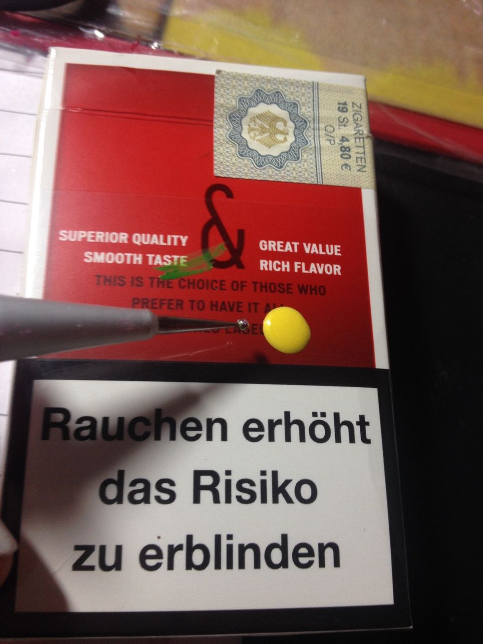 Place a drop of the yellow nail polish on a piece of paper. Dip the dotting tool into it.