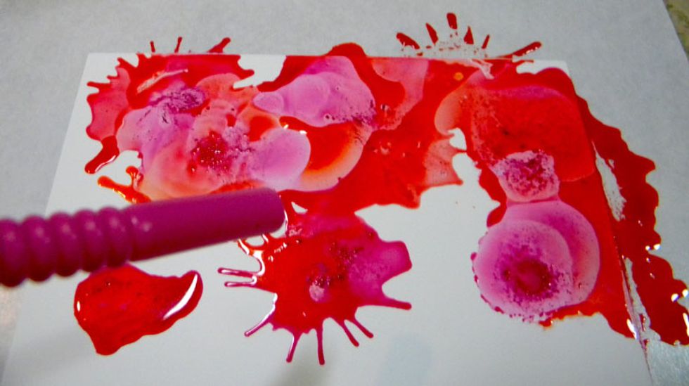 Place a few drops of pink (Enchanting) onto the paper and blow through a straw onto the inks. It's best to start with fewer drops of ink because it's easier to control the flow.