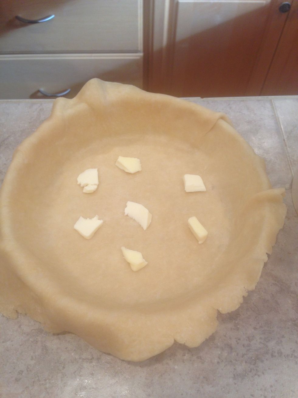 Place a few small slices of butter in bottom of pie crust.