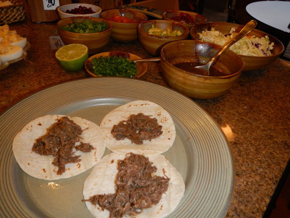 Place a few spoonfuls of shredded meat on each tortilla