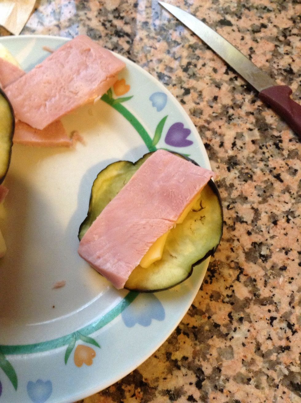 Place a ham slice and a cheese slice on each eggplant slice.