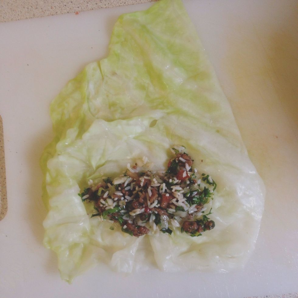 Place a heaping tbsp of the rice filling on the bottom of the cabbage leaf. (Adjust filling amount depending on size of leaf.)