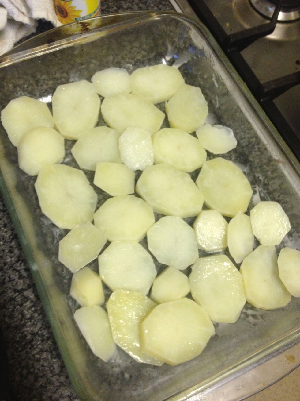 Place a layer of potatoes on the tray and salt them.
