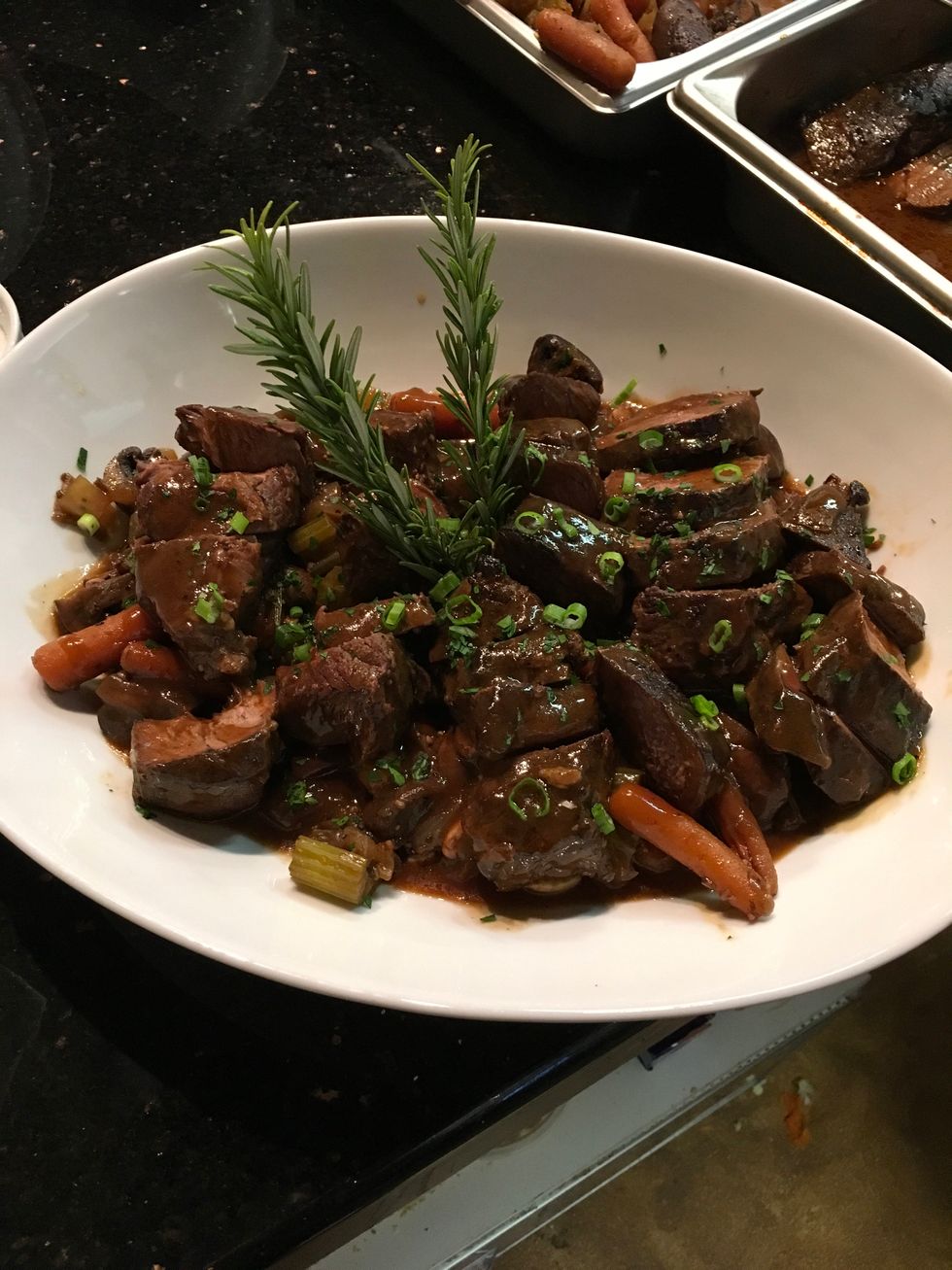 Place a layer of vegetables on bottom of dish, cut each beef rib and place in an even row on top of vegetables. Pour sauce over top and garnish with rosemary.  Enjoy!