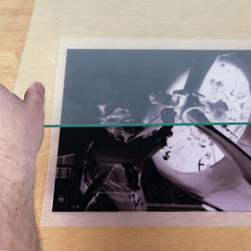 Place a piece of glass on top of silk & negative. This will hold the negative down during exposure and yield the sharpest prints. Note: Glass blocks some UV rays so exposure time may increase.