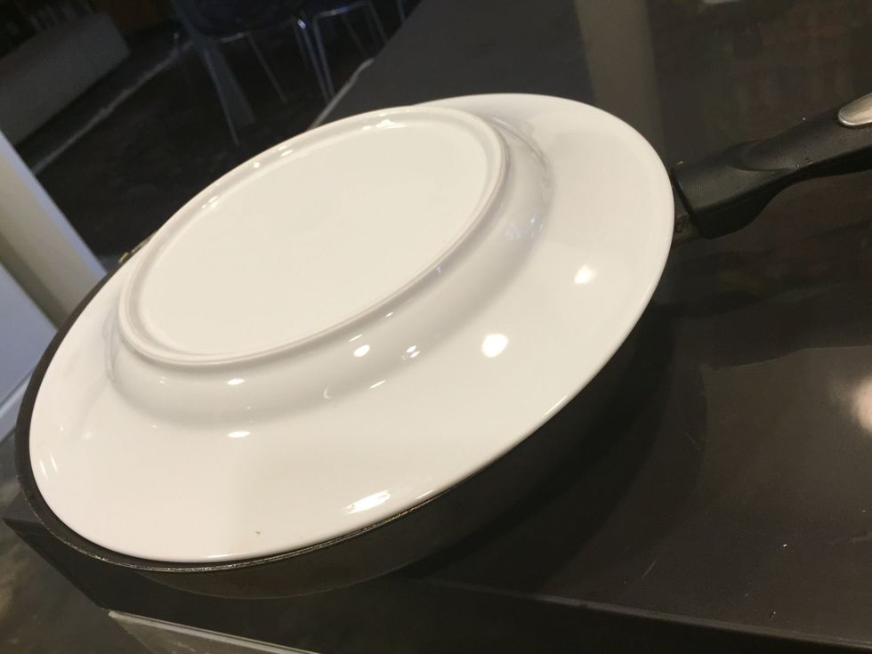 Place a plate over the rostii and flip the rostii over to prep to cook the other side.