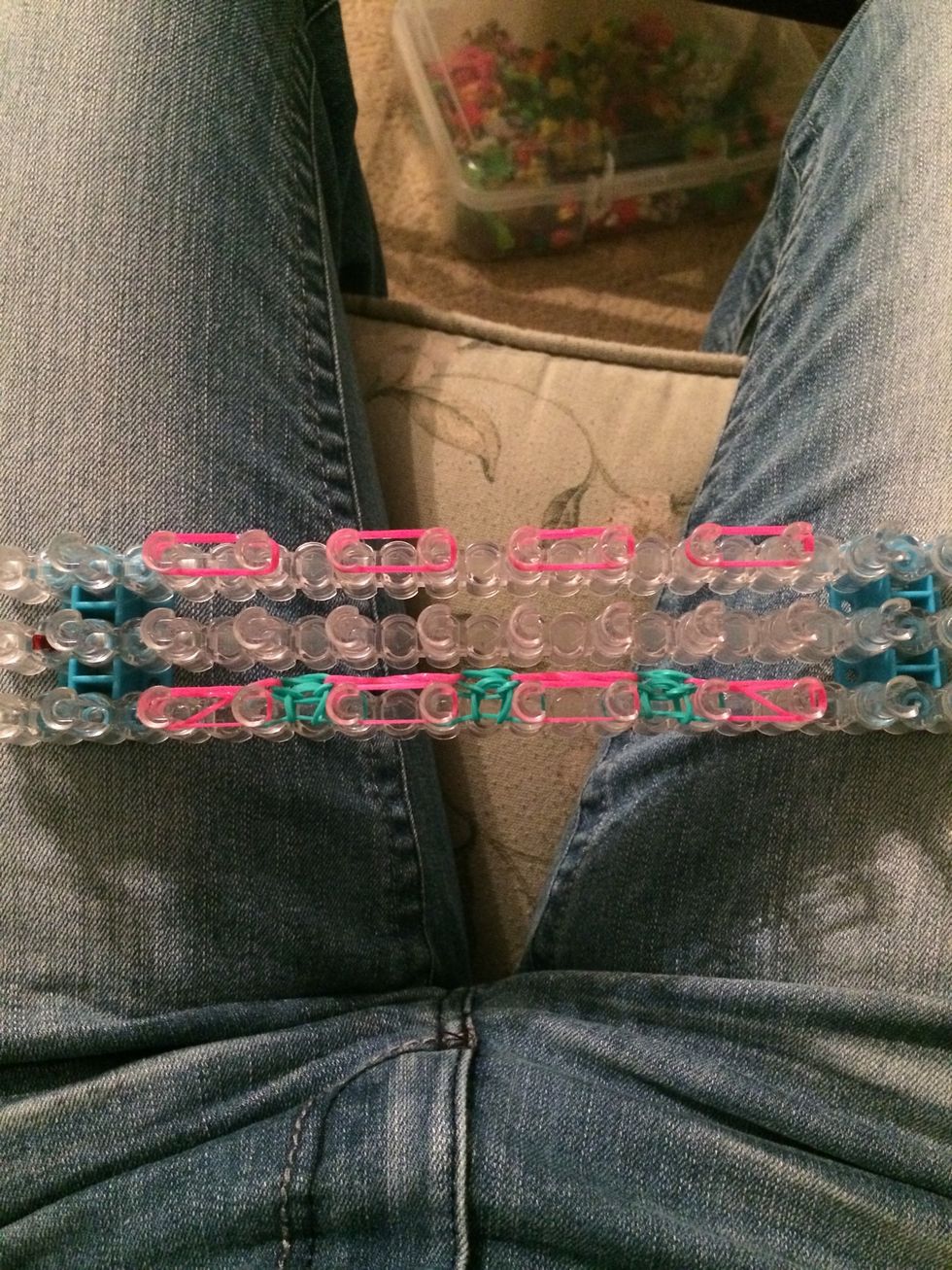 Place a row of pink rubber bands. We will be doing 3 rows of the pink bands just like the blue. This is what gives the bracelet a lacy look. You will see after a few more sets.