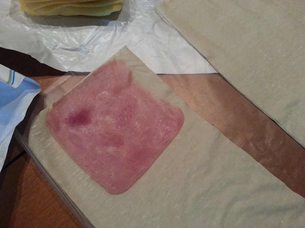 Place a slice of ham and a slice of cheese at one end of the phyllo strip, leave a 1-2cm border