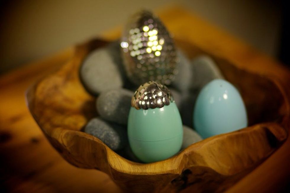 Place a small amount of glue at the top of your egg and glue your first tack on. Continue glueing in a tiered pattern around the first tack. Each tack should cover 1/4-1/2 the tacks above and besides