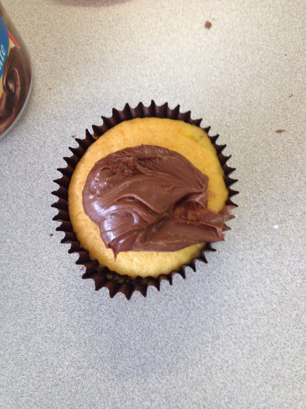 Place a small amount of icing on the cupcake... And spread evenly across the top